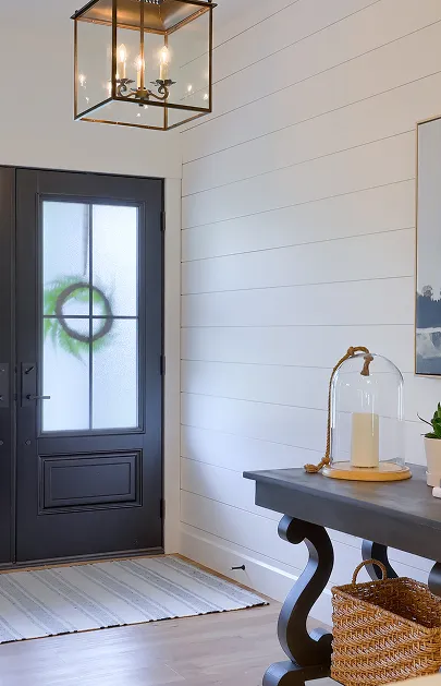 A black door adorned with a decorative wreath, adding a welcoming touch to the entrance.