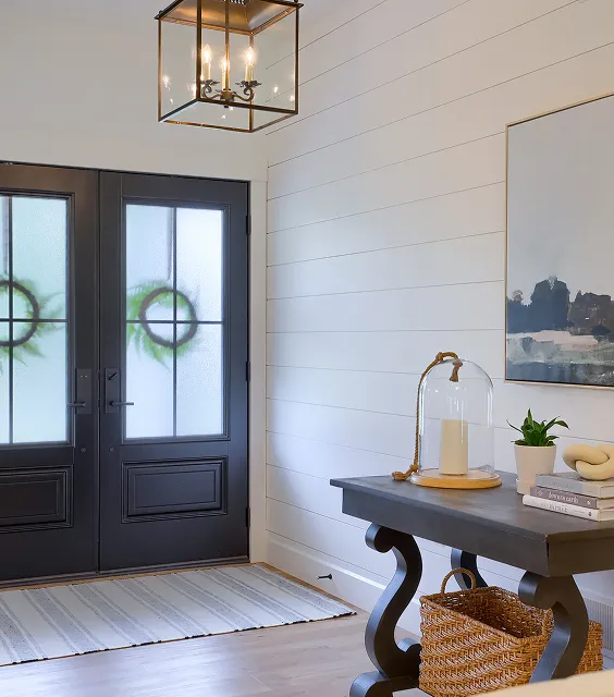 A foyer featuring a table and a decorative wreath hanging on the wall.