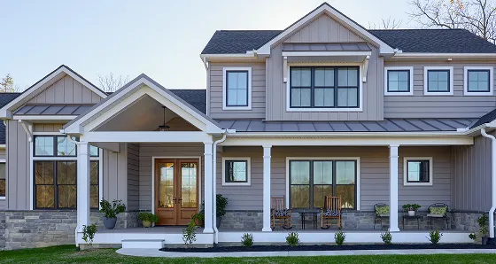 A house featuring a welcoming front porch and a prominent front door.