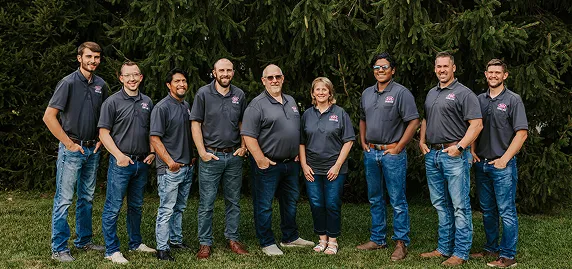 The team at the ISM Construction, poses together, smiling in a professional office setting.
