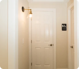 Bright interior hallway featuring a white door, classic gold light fixture, and clean trim work by ISM Construction, a General Contractor in Lebanon, PA.