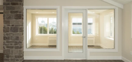 Bright commercial office space viewed through interior glass windows and an entry door, completed by ISM Construction, a General Contractor in Lebanon, PA.