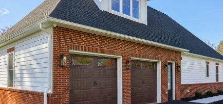 Exterior of a brick-fronted garage designed with high ceilings to accommodate automotive lifts, crafted by ISM Construction, experts in Custom Garages in Lebanon, PA.