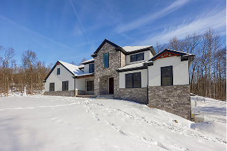 A large house surrounded by a blanket of snow covering the ground, creating a serene winter landscape.