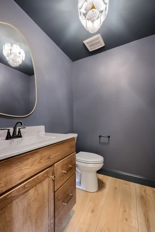 A layered bathroom lighting design by ISM Construction combining dimmable ambient lighting and bright vanity task lighting for both mood and function.