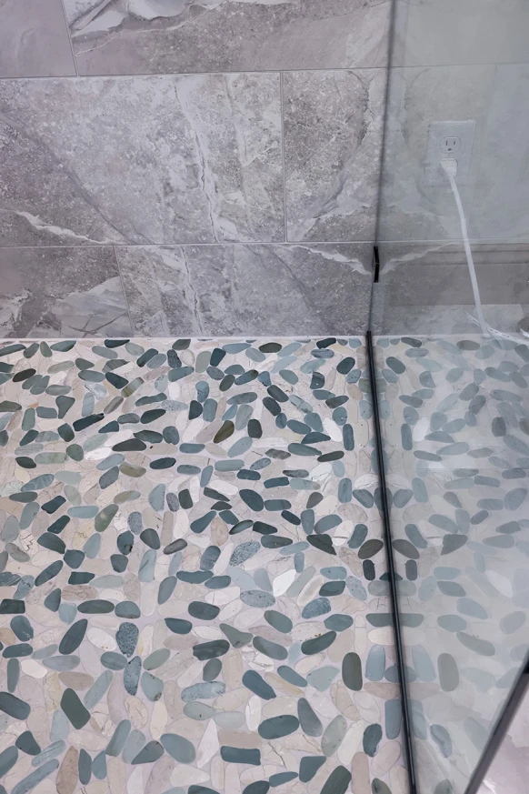 Designer tile and natural stone installed by ISM Construction on bathroom floors, walls, and shower surrounds for a stunning, durable custom look.