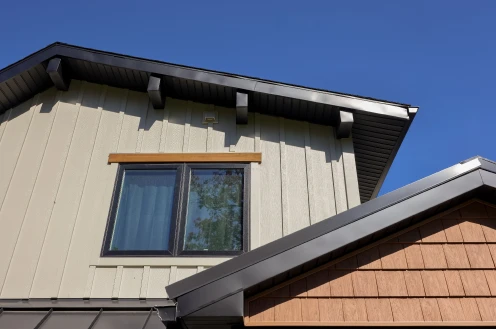 Close-up detail of vertical board and batten siding, custom window trim, and roof flashing installed by ISM Construction, a General Contractor in Lebanon, PA.