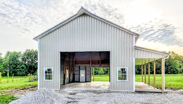 A barn featuring a spacious garage and a prominent large door.